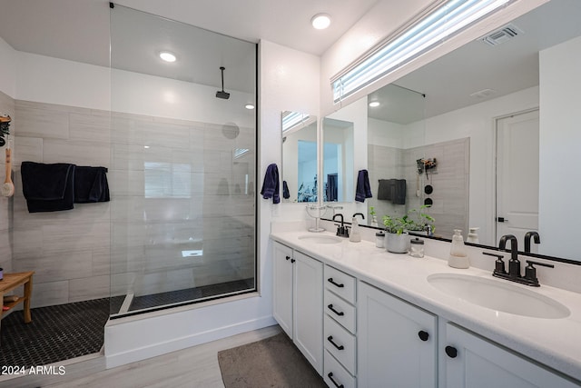 bathroom featuring vanity, hardwood / wood-style floors, and tiled shower