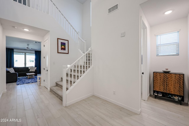 staircase featuring ceiling fan and hardwood / wood-style floors