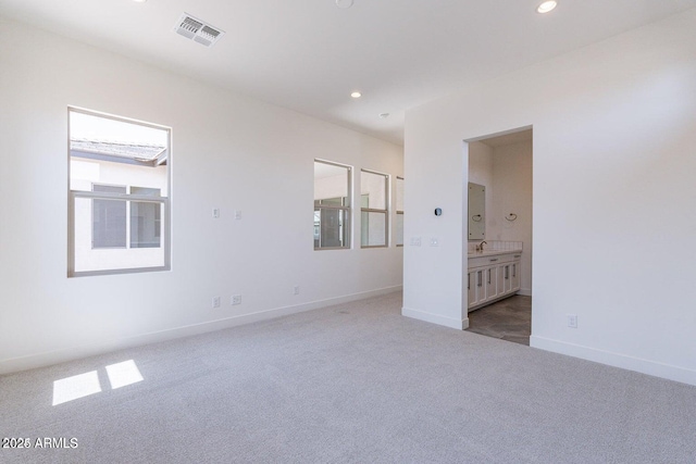 unfurnished bedroom featuring visible vents, ensuite bath, recessed lighting, carpet floors, and baseboards