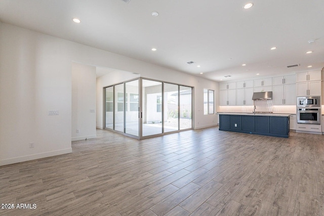 unfurnished living room with recessed lighting, visible vents, baseboards, and light wood-style floors