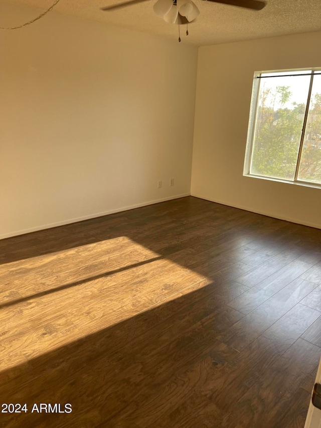 empty room with ceiling fan, a textured ceiling, and wood-type flooring