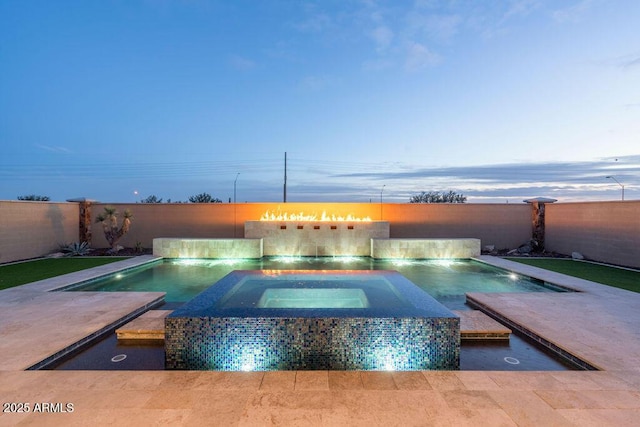 pool at dusk with an in ground hot tub and pool water feature