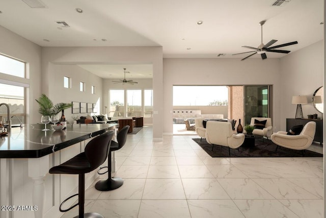 living room featuring plenty of natural light and ceiling fan