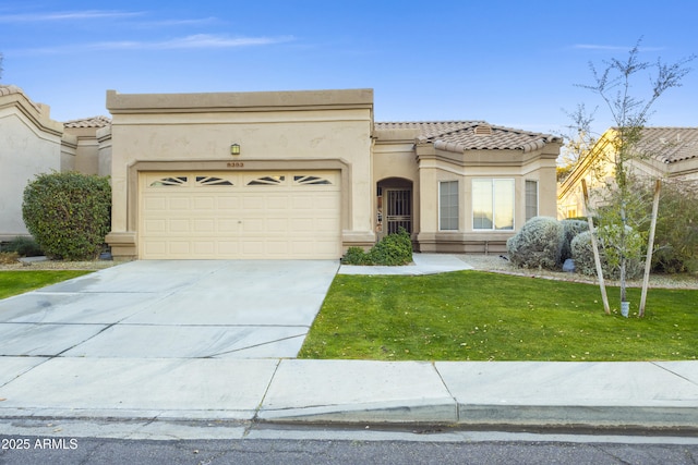 mediterranean / spanish home featuring a front yard and a garage