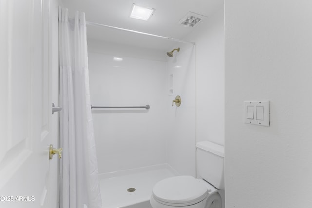 bathroom with curtained shower and toilet