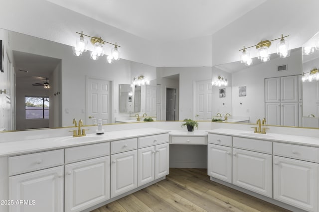 bathroom with ceiling fan, hardwood / wood-style floors, and vanity