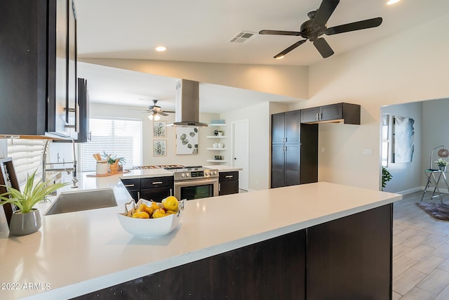 kitchen featuring visible vents, light countertops, stainless steel range with electric stovetop, island exhaust hood, and a ceiling fan