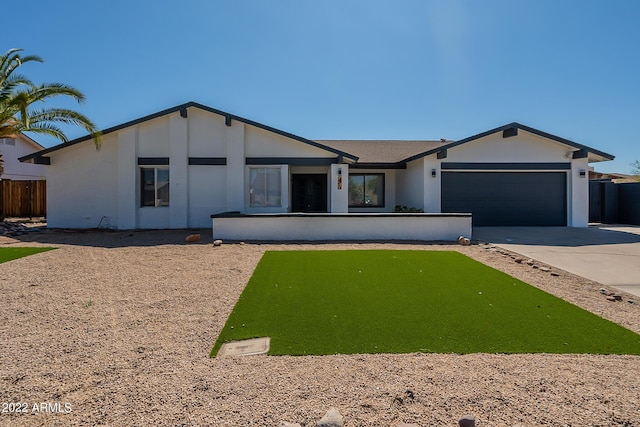 view of front of property with an attached garage, fence, and driveway