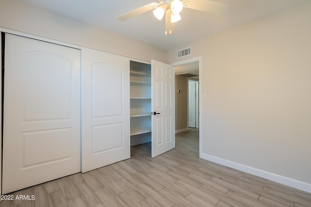 unfurnished bedroom with light wood-type flooring, visible vents, a ceiling fan, a closet, and baseboards