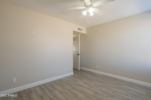 empty room featuring light wood-type flooring, visible vents, baseboards, and ceiling fan