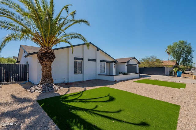 view of front of property featuring stucco siding, driveway, a gate, fence, and an attached garage