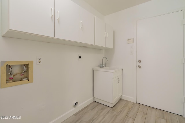 clothes washing area with wood finish floors, a sink, cabinet space, hookup for an electric dryer, and hookup for a washing machine