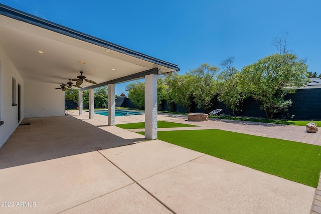 view of patio with a fenced backyard, an outdoor fire pit, and a ceiling fan