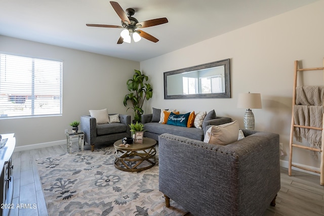 living area featuring baseboards, wood finished floors, and a ceiling fan