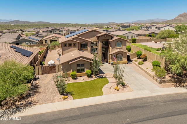 4418 W Yoosooni Dr, New River, AZ 85087 - mediterranean / spanish-style house featuring a residential view, concrete driveway, stucco siding, and a mountain view