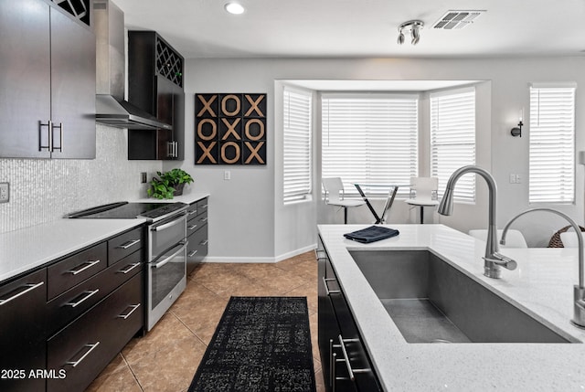 4418 W Yoosooni Dr, New River, AZ 85087 - kitchen with wall chimney exhaust hood, range with two ovens, light countertops, backsplash, and light tile patterned floors