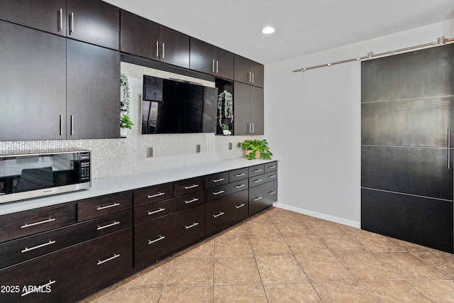 4418 W Yoosooni Dr, New River, AZ 85087 - kitchen with stainless steel microwave, light countertops, light tile patterned flooring, recessed lighting, and tasteful backsplash