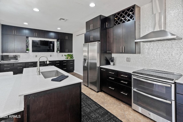 4418 W Yoosooni Dr, New River, AZ 85087 - kitchen with appliances with stainless steel finishes, wall chimney range hood, light countertops, decorative backsplash, and light tile patterned flooring