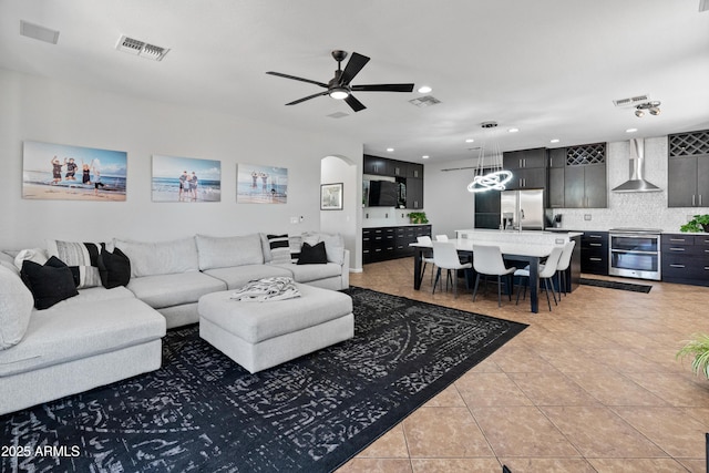 4418 W Yoosooni Dr, New River, AZ 85087 - living room featuring light tile patterned flooring, arched walkways, a ceiling fan, and recessed lighting