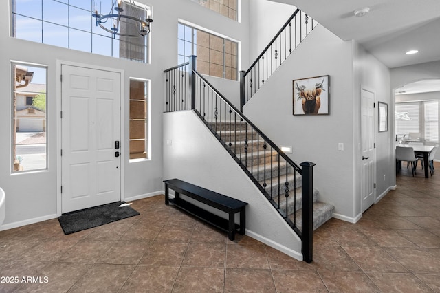 4418 W Yoosooni Dr, New River, AZ 85087 - tiled entryway with arched walkways, stairway, a chandelier, a high ceiling, and recessed lighting