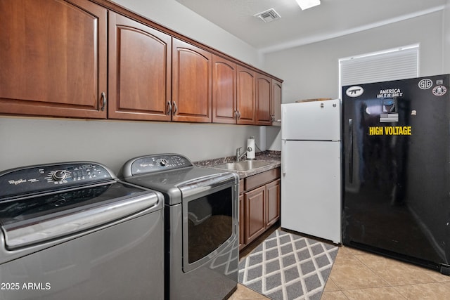 4418 W Yoosooni Dr, New River, AZ 85087 - laundry room featuring washing machine and clothes dryer, cabinet space, and light tile patterned floors