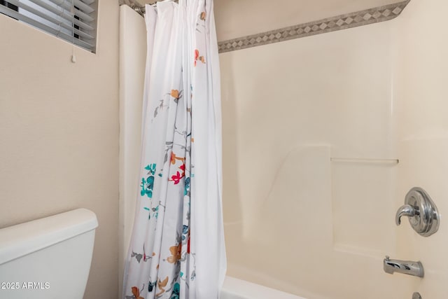 bathroom with shower / bath combination with curtain and toilet