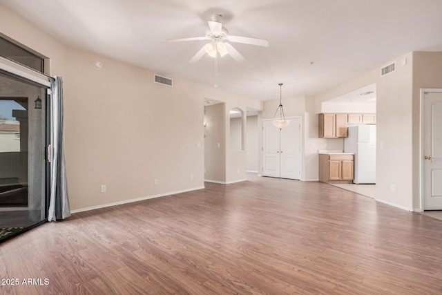 unfurnished living room featuring hardwood / wood-style flooring and ceiling fan