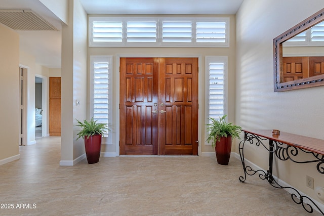 foyer with a healthy amount of sunlight and a towering ceiling