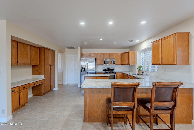 kitchen with stainless steel appliances, a kitchen bar, sink, and kitchen peninsula