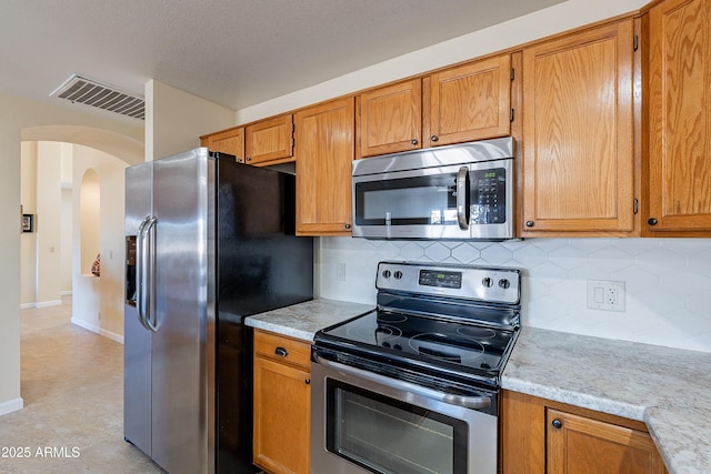 kitchen with appliances with stainless steel finishes and backsplash