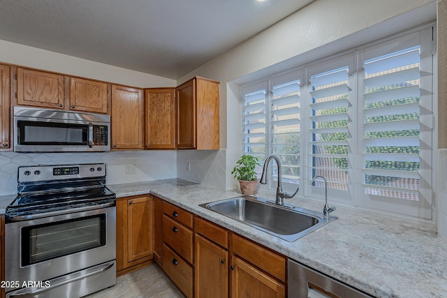 kitchen with stainless steel appliances, sink, and backsplash