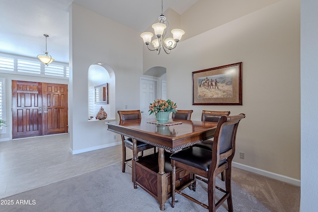 dining space featuring a high ceiling, carpet floors, and a notable chandelier