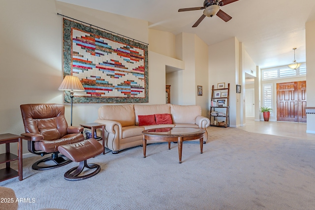 carpeted living room with a towering ceiling and ceiling fan