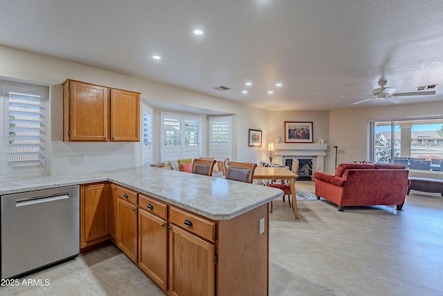 kitchen featuring ceiling fan, stainless steel dishwasher, and kitchen peninsula