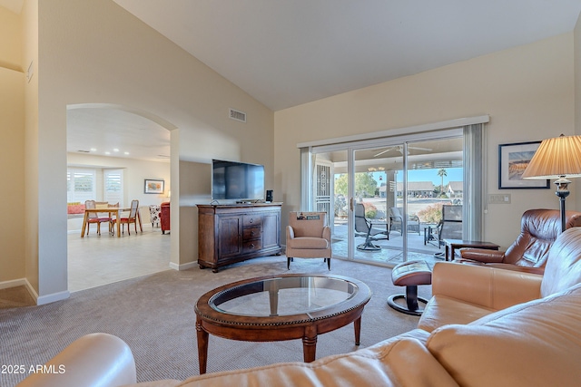 carpeted living room with high vaulted ceiling and a wealth of natural light