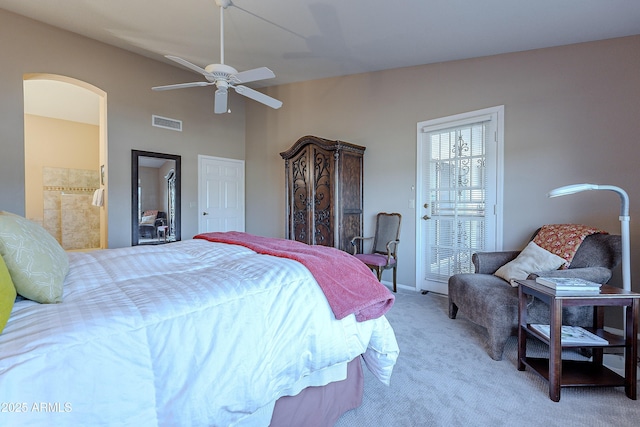 carpeted bedroom with vaulted ceiling, ensuite bath, and ceiling fan