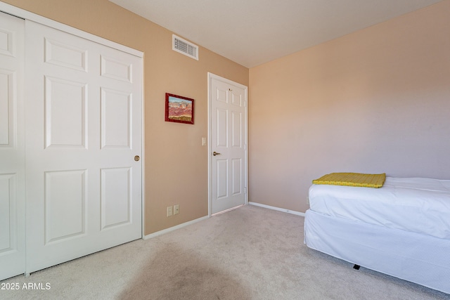 unfurnished bedroom with a closet and light carpet