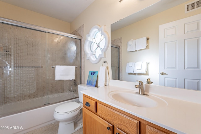 full bathroom with enclosed tub / shower combo, vanity, and toilet