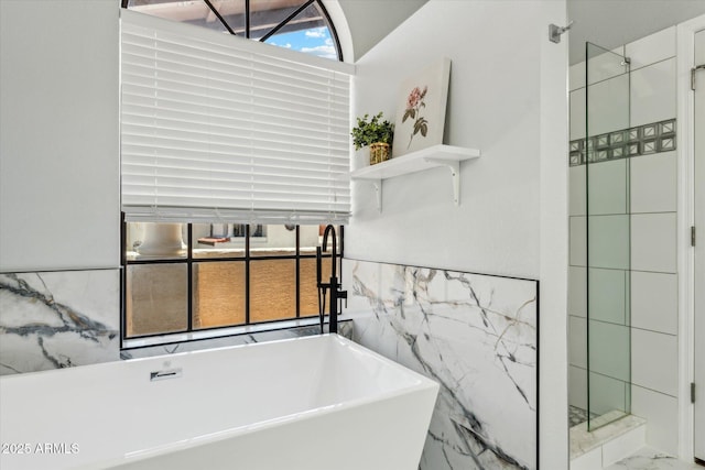 full bathroom with a soaking tub, tiled shower, and marble finish flooring