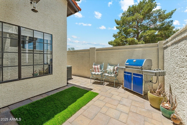 view of patio / terrace with fence, area for grilling, and cooling unit
