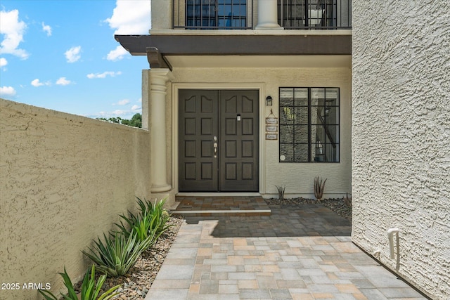 doorway to property featuring stucco siding and a balcony