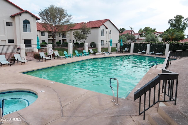 community pool featuring a community hot tub, fence, and a patio