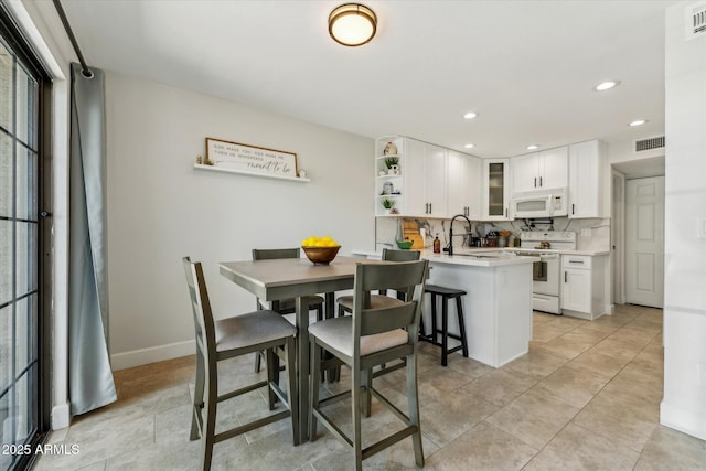 dining area featuring recessed lighting, baseboards, and light tile patterned floors