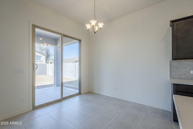 unfurnished dining area featuring light tile patterned floors and a notable chandelier