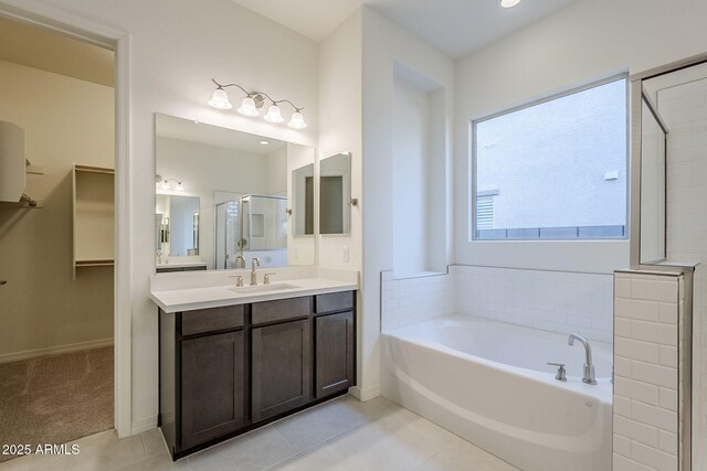 bathroom featuring tile patterned floors, vanity, and shower with separate bathtub