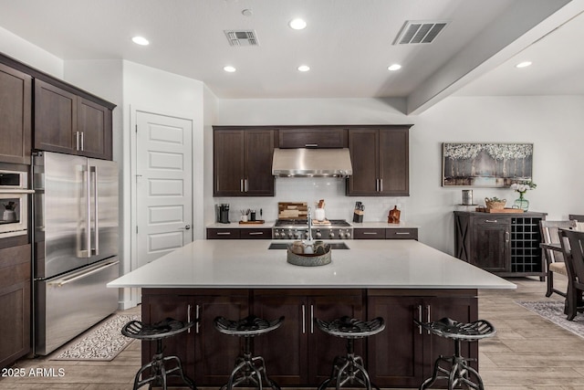 9922 E Thunderbolt Ave, Mesa, AZ 85212 - kitchen featuring stainless steel appliances, under cabinet range hood, light wood-style floors, backsplash, and recessed lighting