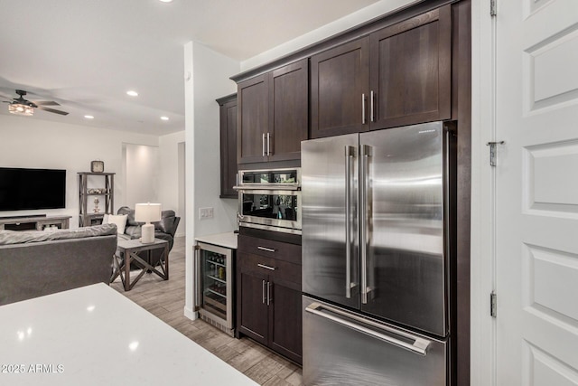 9922 E Thunderbolt Ave, Mesa, AZ 85212 - kitchen with appliances with stainless steel finishes, beverage cooler, light wood-type flooring, dark brown cabinets, and light countertops