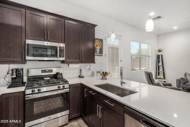 9922 E Thunderbolt Ave, Mesa, AZ 85212 - kitchen featuring stainless steel appliances, a sink, light countertops, dark brown cabinets, and backsplash