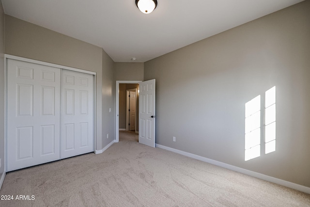 unfurnished bedroom featuring a closet and light carpet