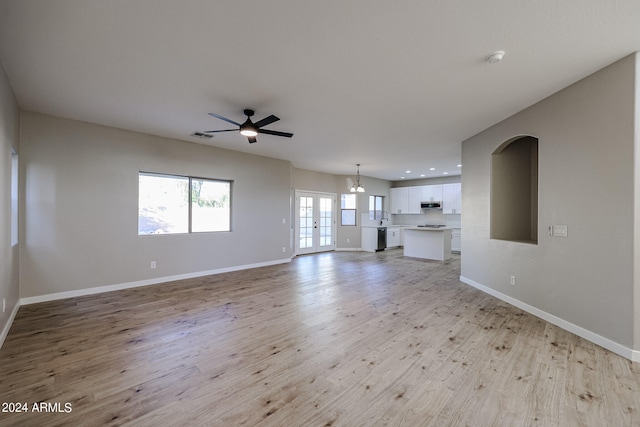 unfurnished living room featuring light hardwood / wood-style floors, french doors, sink, and ceiling fan